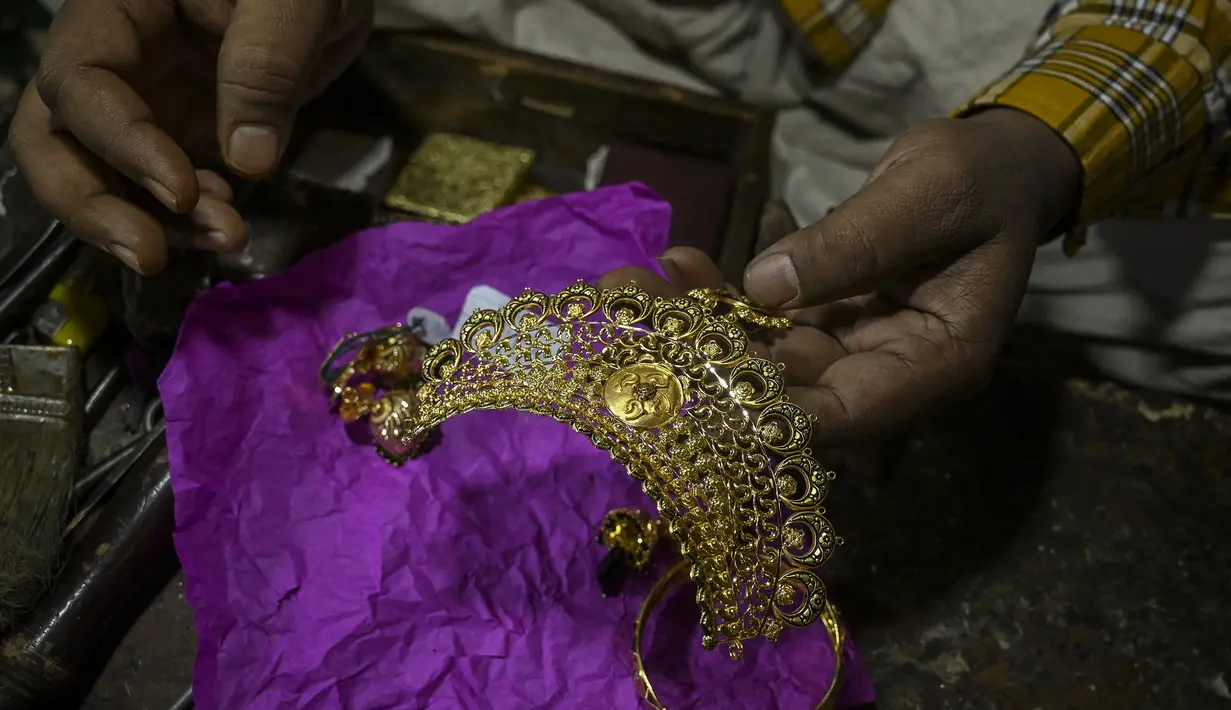 Perajin membuat ornamen di bengkel perhiasan emas di Srinagar (24/6/2021). Srinagar merupakan menjadi salah satu pusat industri kerajinan perhiasan emas. (AFP/Tauseef Mustafa)