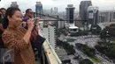 Menteri BUMN, Rini Soemarno mengabadikan gambar demo 2 Desember di atas gedung BUMN, Jakarta, Rabu (2/12). Demo 2 Desember digelar sebagai lanjutan dari aksi 4 November 2016. (Liputan6.com/Ferbian Pradolo)