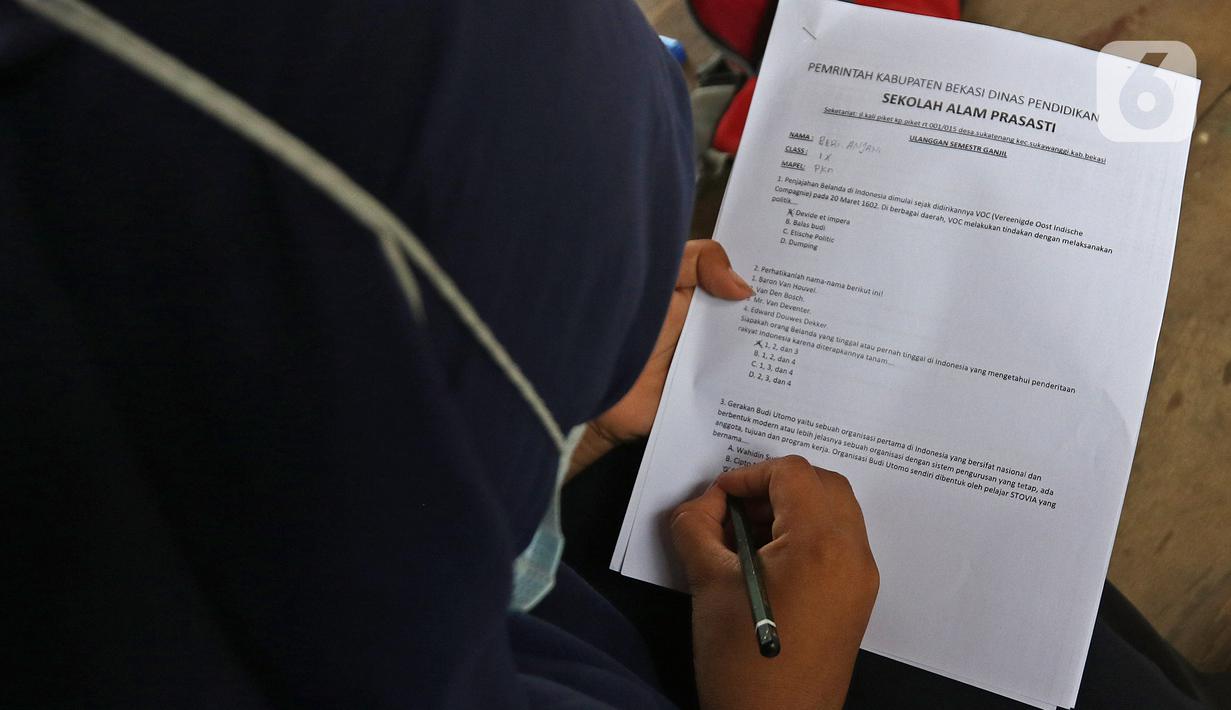 Murid SMP Sekolah Alam mengisi soal Ujian Akhir Semester (UAS) di Sukawangi, Kabuapaten Bekasi, Jawa Barat, Senin (30/11/2020). Menurut pengurus Sekolah Alam KBM tatap muka  jenjang pendidikan SD,SMP, dan SMA tetap berjalan dengan menerapkan protokol kesehatan. (Liputan6.com/Herman Zakharia)