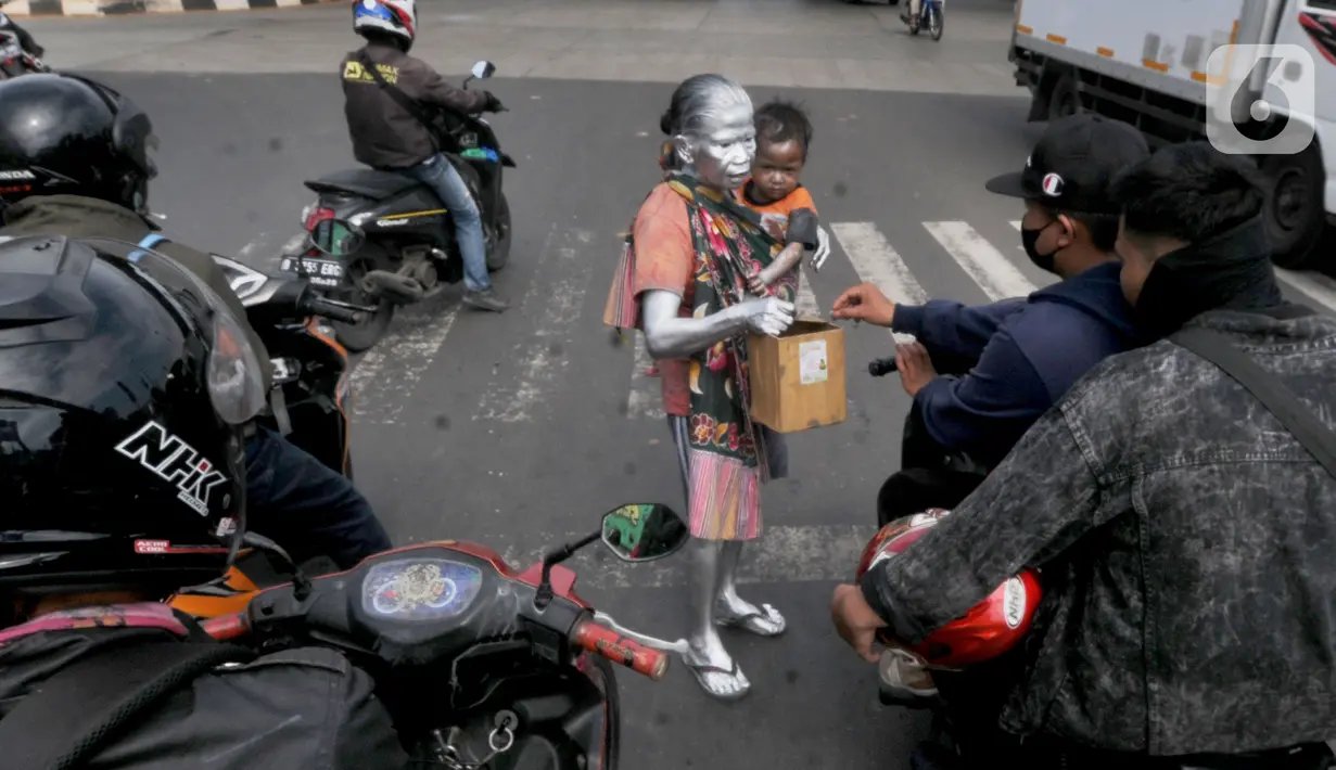 Sudah 4 bulan ini Ia bersama cucu  laki-lakinya  Reihan  (2,5 tahun)  mengamen menjadi manusia silver, setelah sebelumnya ia sempat menjadi pembantu rumah tangga di kawasan Tangerang. (merdeka.com/Arie Basuki)