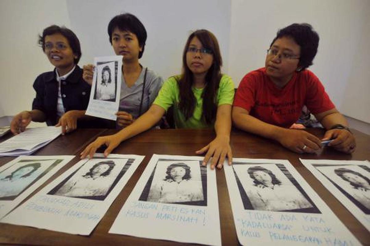 Seorang aktivis menuliskan pesan di foto Marsinah saat konferensi pers 