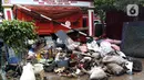 Tumpukan sampah terlihat menumpuk di sepanjang jalan pascabanjir mulai surut di kawasan Kembangan, Jakarta Barat, Minggu (5/1/2020). Nantinya sampah-sampah ini akan diangkut oleh petugas kebersihan menggunakan truk pengangkut sampah yang akan dibawa ke TPA Bantar Gebang.  (Liputan6.com/Johan Tallo)