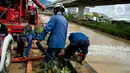 Petugas pemadan kebakaran menyedot air banjir di kawasan Cipinang Melayu, Jakarta, Minggu (21/2/2021). Suku Dinas Pemadam Kebakaran Jakarta Timur mengerahkan 20 mobil pompa untuk menyedot air yang membanjiri RW 04 Kelurahan Cipinang Melayu untuk mengurangi debit air. (Liputan6.com/Faizal Fanani)