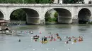Sejumlah peserta mendayung kanonya saat mengikuti International Tiber Canoe Descent di sungai Tiber di Roma, Italia (5/1). Olahraga kano ini terbagi menjadi beberapa jenis,  antara lain adalah Sprin, Slalom, dan Polo. (AFP Photo/Andreas Solaro)