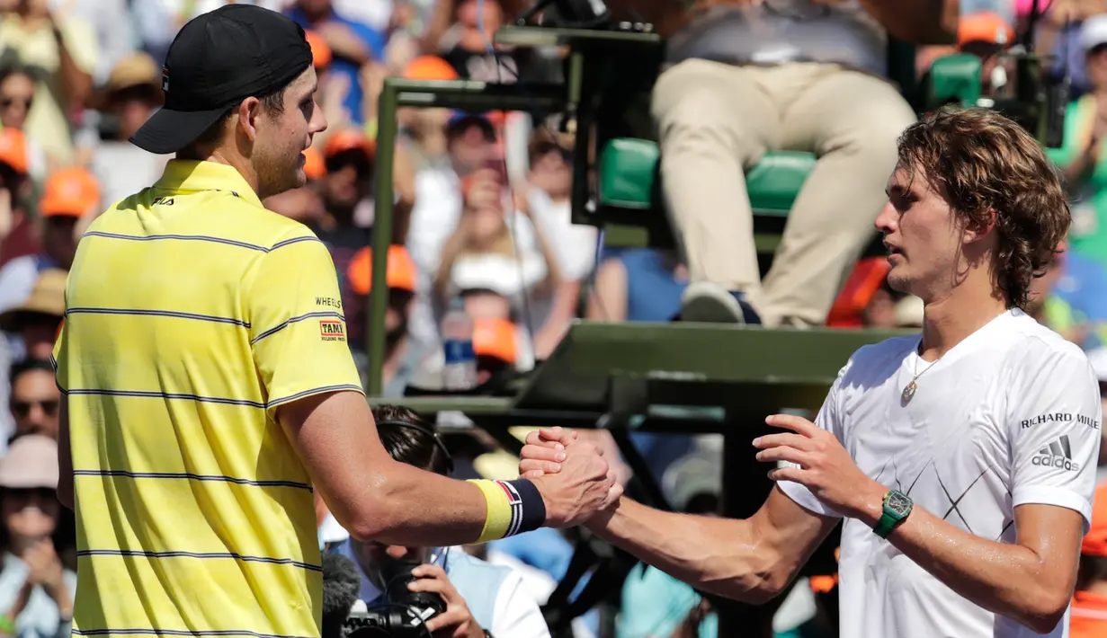 Petenis AS, John Isner berjabat tangan dengan petenis Jerman, Alexander Zverev seusai final Miami Terbuka 2018 di Key Biscayne, Minggu (1/4). John Isner meraih gelar juara Miami Terbuka setelah menang dengan skor, 6-7(4), 6-4 dan 6-4.  (AP/Lynne Sladky)