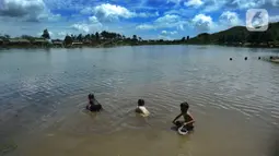 Anak-anak mengumpulkan kerang atau kijing di kawasan Situ Rawa Gede, Sirnajaya, Bogor, Jumat (6/1/2023). Mengisi waktu libur sekolah, mereka membantu orang tuanya dengan mengumpulkan kerang yang dijual sebesar Rp 5ribu per kg. (merdeka.com/ Arie Basuki)