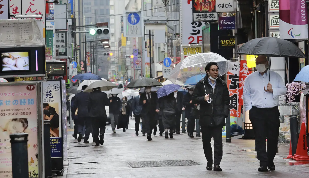 Warga memakai masker untuk melindungi dari penyebaran virus corona berjalan di jalan yang dipenuhi bar dan restoran di Tokyo (8/3/2021). Pemerintah Jepang memperpanjang keadaan darurat di wilayah Tokyo hingga 21 Maret karena sistem medis masih disaring oleh pasien COVID-19. (AP Photo/Koji Sasahara)