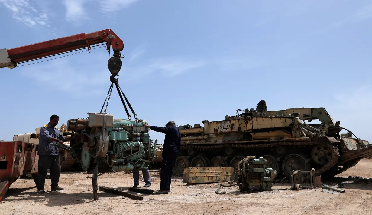 Teknisi militer Pasukan Mobilisasi Populer Irak (Hashid Shaabi) memperbaiki mesin tank di sebuah bengkel di Kerbala, Irak (7/5). Bengkel yang terletak di Kerbala ini menjadi lokasi perbaikan kendaraan-kendaraan militer rusak usai dipergunakan untuk perang. (Reuters/Abdullah Dhiaa Al- Dien)
