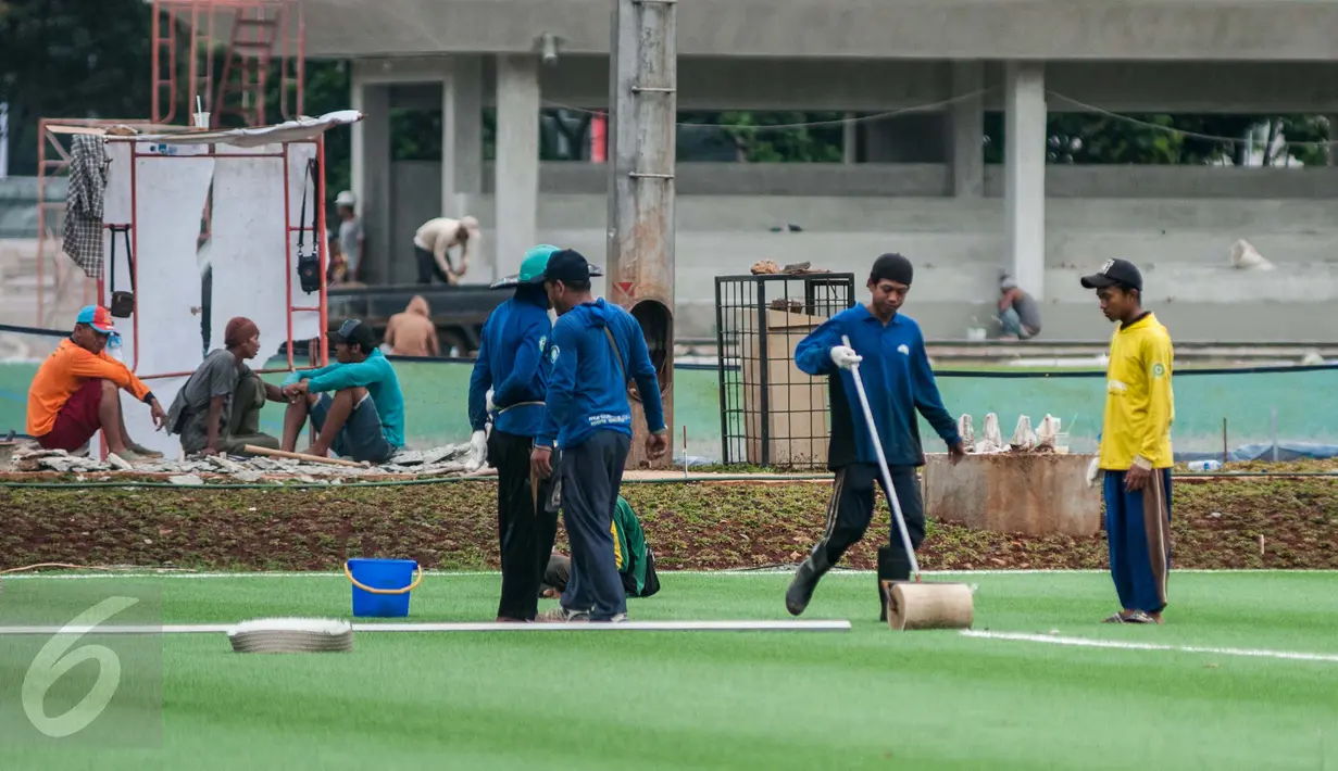 Pekerja menyelesaikan renovasi lapangan latihan timnas Indonesia di Kompleks Gelora Bung Karno, Senayan, Jakarta, Rabu (10/5). Pemerintah melakukan renovasi total kawasan Gelora Bung Karno guna menyambut Asian Games 2018. (Liputan6.com/Gempur M Surya)