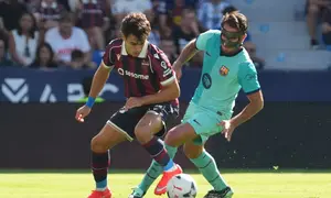 Pemain Levante Manu Sanchez (kiri) dan pemain Barcelona Eric Garcia berebut bola dalam pertandingan Liga Spanyol di Estadio Ciudad de Valencia, Minggu (13/9/2026). (AP Photo/Alberto Saiz)