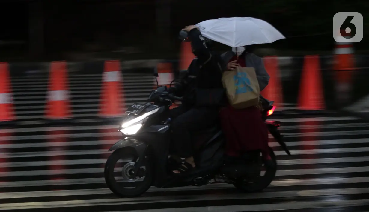 Pengendara motor mengenakan jas hujan saat melintas di kawasan Kuningan, Jakarta, Selasa (8/11/2022). Curah hujan yang tinggi di kawasan Jakarta berpotensi menimbulkan genangan atau banjir sehingga berpotensi memicu kemacetan, terutama saat jam kerja. (Liputan6.com/Helmi Fithriansyah)
