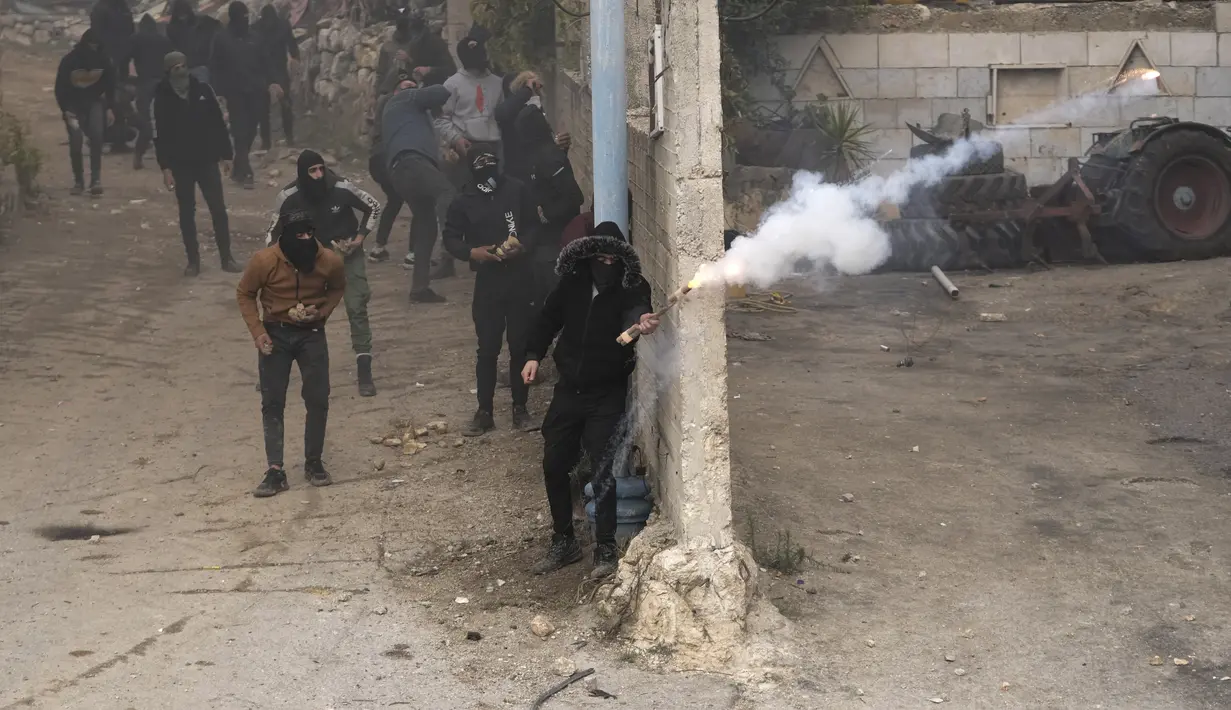 Warga Palestina membakar ban saat bentrok dengan pasukan keamanan Israel setelah pemakaman Mufid Khalil di desa Beit Ummar, Tepi Barat, dekat Hebron (29/11/2022). Kementerian Kesehatan Palestina mengatakan, Khalil terbunuh oleh tembakan Israel di Tepi Barat yang diduduki.  (AP Photo/Mahmoud Illean)