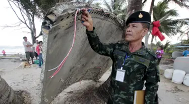 Tentara memeriksa potongan pesawat yang ditemukan di pantai Thailand selatan, provinsi Nakhon Si Thammarat, Minggu (24/1). Sebuah bagian pesawat yang diduga dari pesawat Malaysia Airlines MH370 ditemukan oleh warga sekitar. (REUTERS/Surapan Boonthanom)