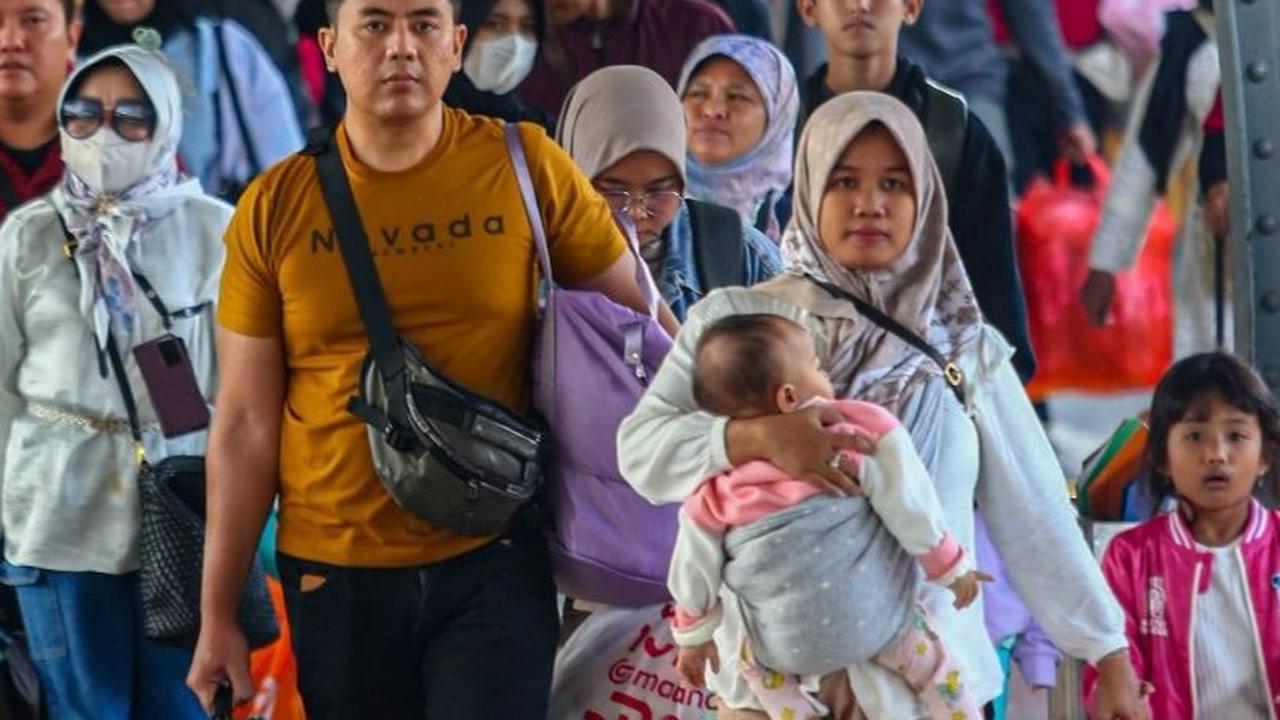 Dengan membawa banyak barang bawaannya, para penumpang berjalan kaki menuju pintu keluar Stasiun Senen. Foto: Liputan6.com / Angga Yuniar