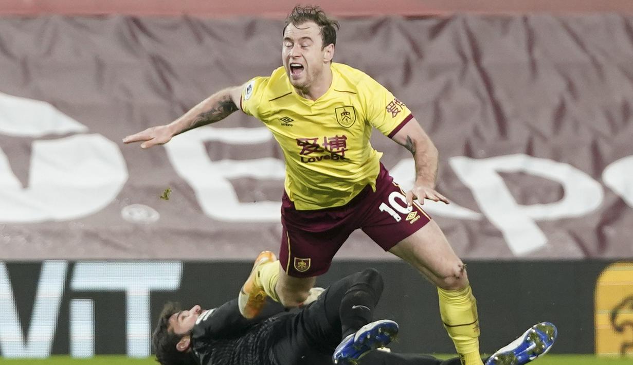 Striker Burnley, Ashley Barnes dijatuhkan penjaga gawang Liverpool, Alisson Becker yang membuahkan hukuman penalti dalam laga lanjutan Liga Inggris 2020/21 di Anfield Stadium, Liverpool, Kamis (21/1/2021). Burnley menang 1-0 atas Liverpool. (AFP/Jon Super/Pool)