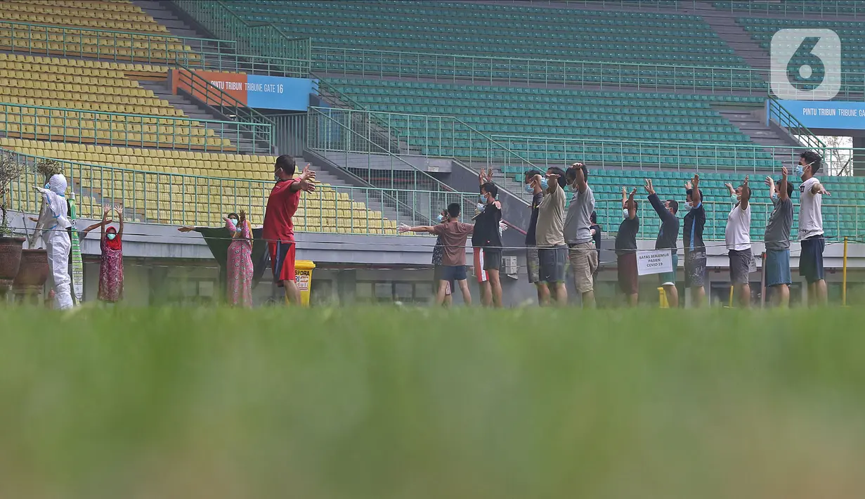 Sejumlah pasien berstatus orang tanpa gejala (OTG) senam bersama tim medis di Stadion Patriot Chandrabaga, Bekasi, Jawa Barat, Minggu (27/9/2020). Dari 28 pasien OTG, beberapa di antaranya mengikuti senam di arena stadion karena masih menunggi hasil pemeriksaan. (Liputan6.com/Herman Zakharia)