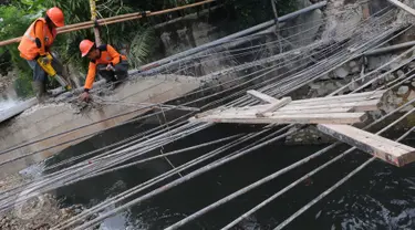 Petugas Suku Dinas Bina Marga Jakarta Barat memperbaiki Jembatan Kali Inspeksi Grogol, Jakarta, (30/5/2016). Amblesnya jembatan yang terletak depan kompleks Hankam, Palmerah tersebut penyebabnya diduga terjadi pergeseran tanah (Liputan6.com/Helmi Afandi)