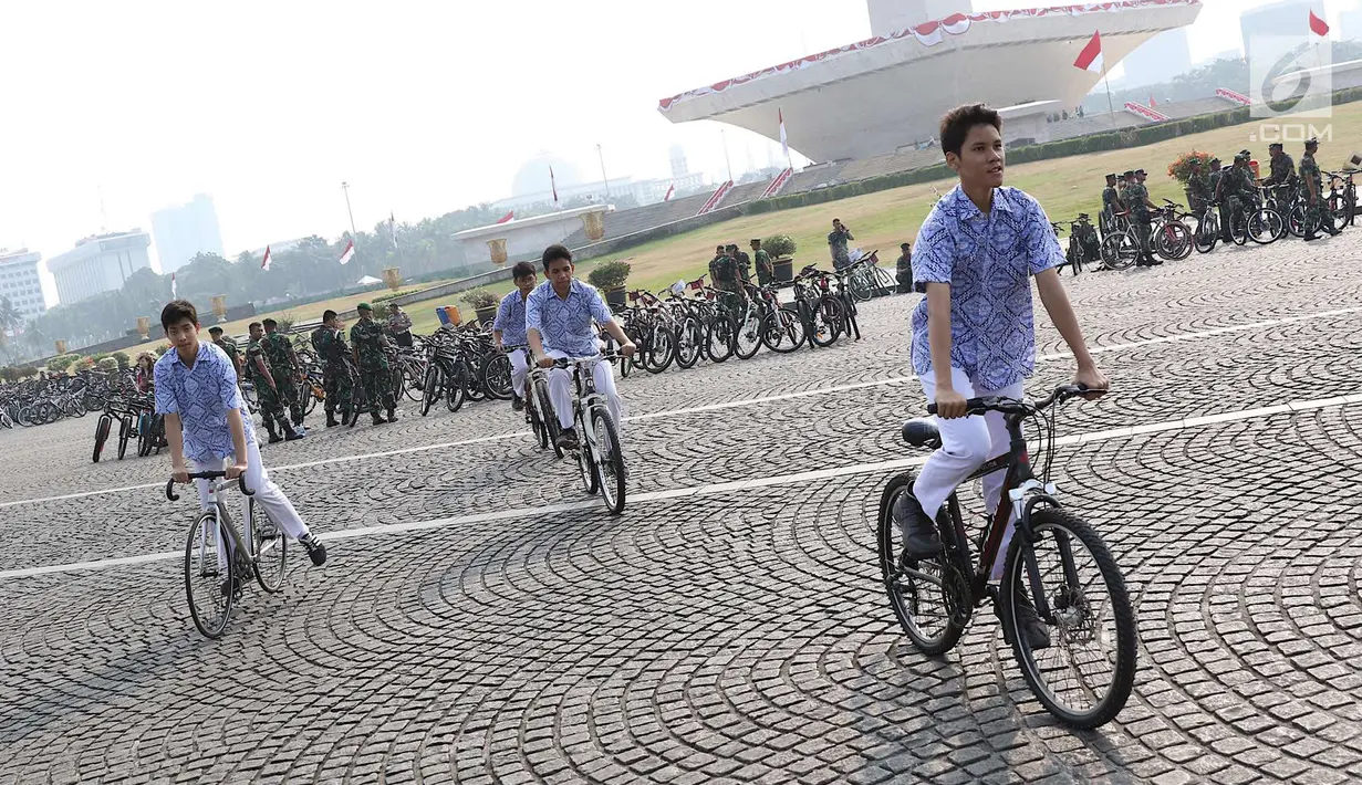 Pelajar mengikuti kegiatan Sepeda Nusantara 2018 di kawasan Monas, Jakarta, Kamis (9/8). Selain untuk mendukung program membuat langit Jakarta biru bebas dari polusi, program jni juga untuk menyambut Asian Games 2018. (Liputan6.com/Immanuel Antonius)