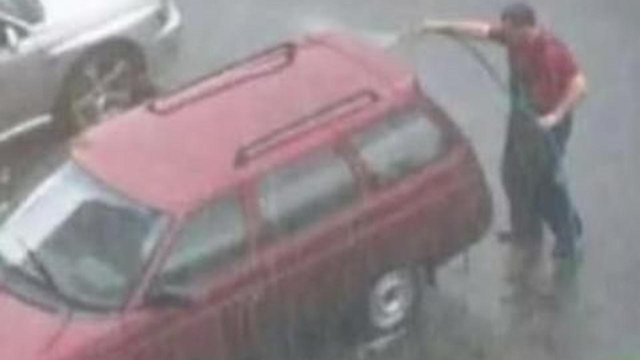 Di bawah guyuran hujan, mobil dicuci