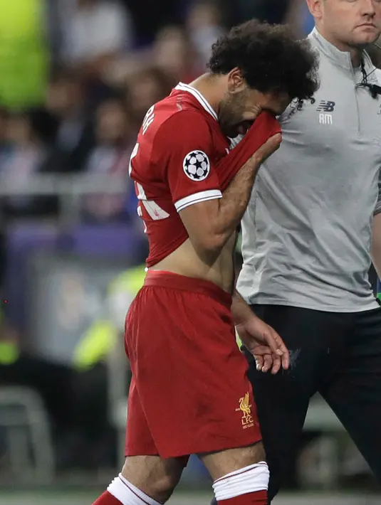 Pemain depan Liverpool Mohamed Salah meninggalkan lapangan sambil menangis usai cedera saat melawan Real Madrid dalam pertandingan final Liga Champions di Stadion NSK Olimpiyskiy, Ukraina (26/5). (AP / Matthias Schrader)
