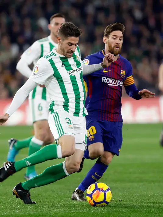 Pemain Barcelona, Lionel Messi  berebut bola dengan pemain Real Betis, Javi Garcia pada pertandingan lanjutan La Liga di Stadion Benito Villamarin, Minggu (21/1). Dua gol Messi membawa Barcelona menang telak 5-0 atas Real Betis. (AP/Miguel Morenatti)