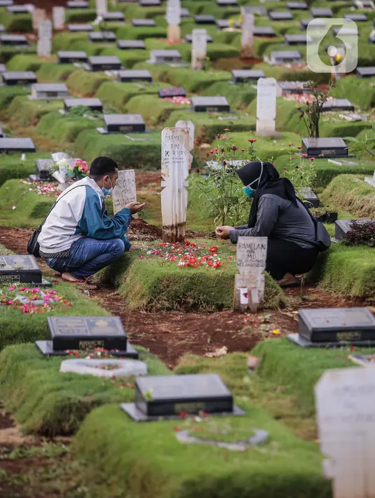 Umat Muslim berdoa di makam keluarga saat melakukan ziarah di Tempat Pemakaman Umum (TPU) Pondok Ranggon, Jakarta, Minggu (04/04/21). Meskipun di tengah pandemi Covid-19 warga tetap melakukan tradisi ziarah kubur. menjelang bulan Ramadan. (Liputan6.com/Faizal Fanani)