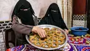 Kesibukan anggota keluarga Palestina menyiapkan kue-kue tradisional untuk dijual sebagai persiapan liburan Idul Fitri mendatang, di kota Rafah, Jalur Gaza, Selasa (4/5/2021). Pembuatan kue tradisional untuk Hari Raya Idul Fitri atau Lebaran yang menandai akhir bulan Ramadhan. (KATA KHATIB/AFP)