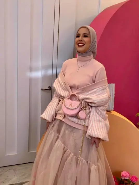 Gayanya disempurnakan dengan mini bag dan hijab warna nude pink. (Instagram/tya_ariestya).