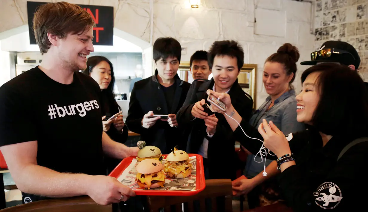 Pengunjung memfoto burger berkarakter pokemon di restoran Down N 'Out Burger, Sydney, Australia, (26/8).  Restoran ini menyebut burger kreasi mereka dengan sebutan "Pokeburg". (REUTERS/Jason Reed)