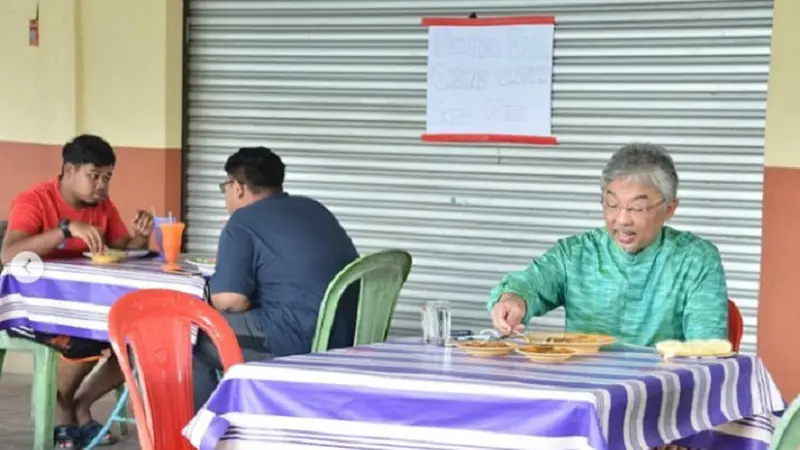 Tiga foto sang Raja, mengenakan baju hijau dan celana hitam, menikmati waktunya sendirian sambil makan, diunggah di akun resmi Facebook dan Instagram Istana Negara (@istana_negara)