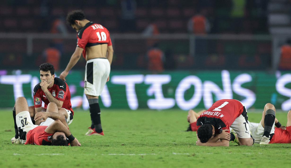 Striker Mesir, Mohamed Salah (tengah) dan para pemain lainnya tampak kecewa usai dikalahkan Senegal 2-4 melaui adu penalti  dalam laga final Piala Afrika 2021 di Stade d'Olembe, Yaounde, Kamerun (6/2/2022). (AFP/Kenzo Tribouillard)