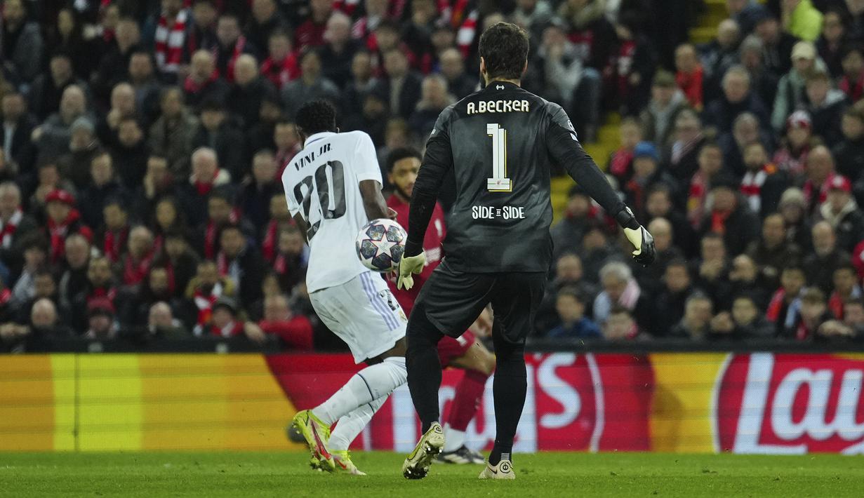 Kiper Liverpool, Alisson Becker (kanan) berusaha menghalau bola namun membentur pemain Real Madrid yang berujung menjadi gol saat laga leg pertama Liga Champions 2022/2023 yang berlangsung di Anfield, Rabu (22/02/2023) WIB. Liverpool kalah dengan skor 2-5 dari Real Madrid. (AP Photo/Jon Super)