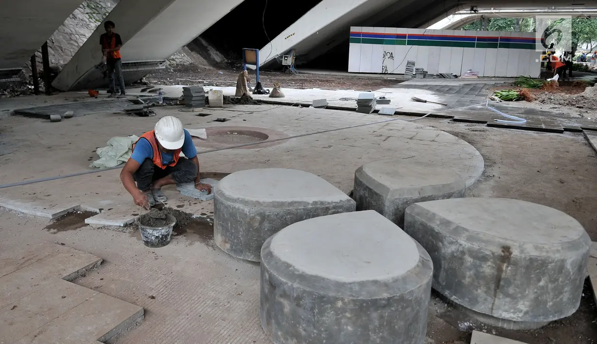 Pekerja menyelesaikan pembangunan taman di kolong Jembatan Semanggi, Jakarta, Kamis (7/3). Nnatinya, taman kolong Jembatan Semanggi akan difungsikan saat car free day yang diisi dengan kegiatan pengembangan seni budaya. (merdeka.com/Iqbal Nugroho)