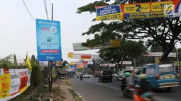 Kendaraan melintas di bawah spanduk iklan penjualan properti yang menghiasi ruas jalan kawasan Cibubur, Jakarta, Minggu (26/8). Keberadaan spanduk promosi perumahan yang tidak tepat juga bisa mengotori pemandangan jalan. (Liputan6.com/Immnuel Antonius)