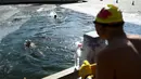 Dua perenang es berenang di danau yang membeku pada hari musim dingin di Beijing (6/1/2021). Berenang di musim dingin adalah kegiatan olahraga yang jarang dijumpai kecuali di beberapa negara dengan musim dingin yang cukup panjang. (AFP/Wang Zhao)