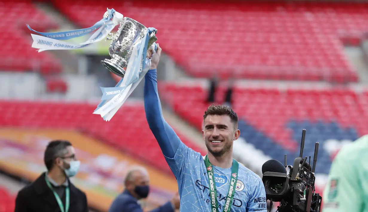 Bek Manchester City, Aymeric Laporte mengangkat trofi saat merayakan kemenangan atas Tottenham Hotspur pada pertandingan final Piala Liga Inggris di stadion Wembley di London, Senin (26/4/2021). (AP Photo/Alastair Grant)