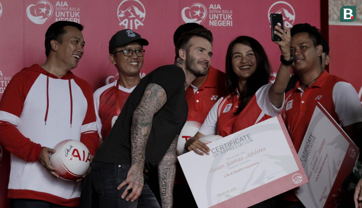 Legenda sepak bola Inggris, David Beckham, foto bersama atlet Indonesia di Stadion Soemantri Brodjonegoro, Jakarta, Minggu (25/3/2018). AIA membagikan 10.000 bola kepada akademi sepak bola di Indonesia. (Bola.com/M Iqbal Ichsan)