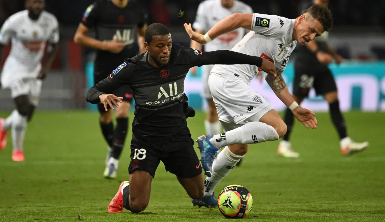Gelandang Paris Saint-Germain (PSG) Georginio Wijnaldum (kiri) berebut bola dengan gelandang Angers Pierrick Capelle pada pekan ke-10 Ligue 1 Prancis 2021/2022 di Parc des Princes, Sabtu (16/10/2021) dini hari WIB. PSG memastikan kemenangan 2-1 lewat gol penalti Kylian Mbappe. (FRANCK FIFE / AFP)