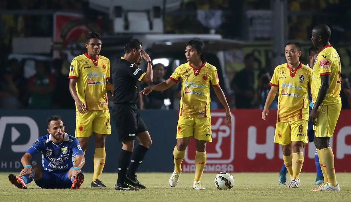 Pemain Sriwijaya FC, Asri Akbar, memprotes wasit Jumadi Effendi, setelah melanggar pemain Persib, Ilija Spasojevic, dalam Final Piala Presiden 2015 di Stadion Utama Gelora Bung Karno, Jakarta, Minggu (18/10/2015). (Bola.com/Nicklas Hanoatubun)