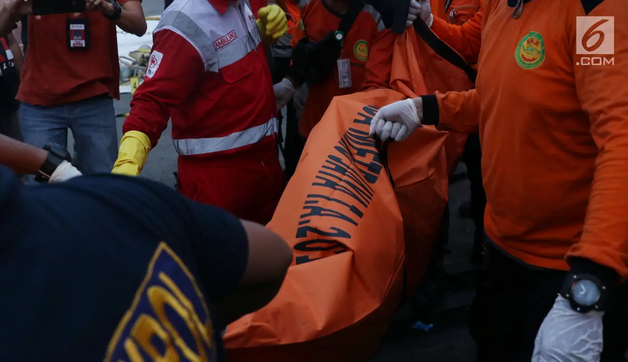 Petugas membawa kantung jenasah diduga penumpang pesawat Lion Air JT 610 di Pelabuhan JICT 2, Jakarta, Selasa (30/10). Sejumlah barang ditemukan petugas gabungan dalam operasi pencarian. (Liputan6.com/Helmi Fithriansyah)