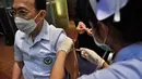Seorang petugas kesehatan menerima vaksin Covid-19 CoronaVac dari Sinovac, di Institut Penyakit Menular Bamrasnaradura di Bangkok, Minggu (28/2/2021). Meski tertinggal diantara negara-negara Asia Tenggara lainnya, akhirnya Thailand memulai kampanye vaksin COVID-19. (Lillian SUWANRUMPHA/AFP)