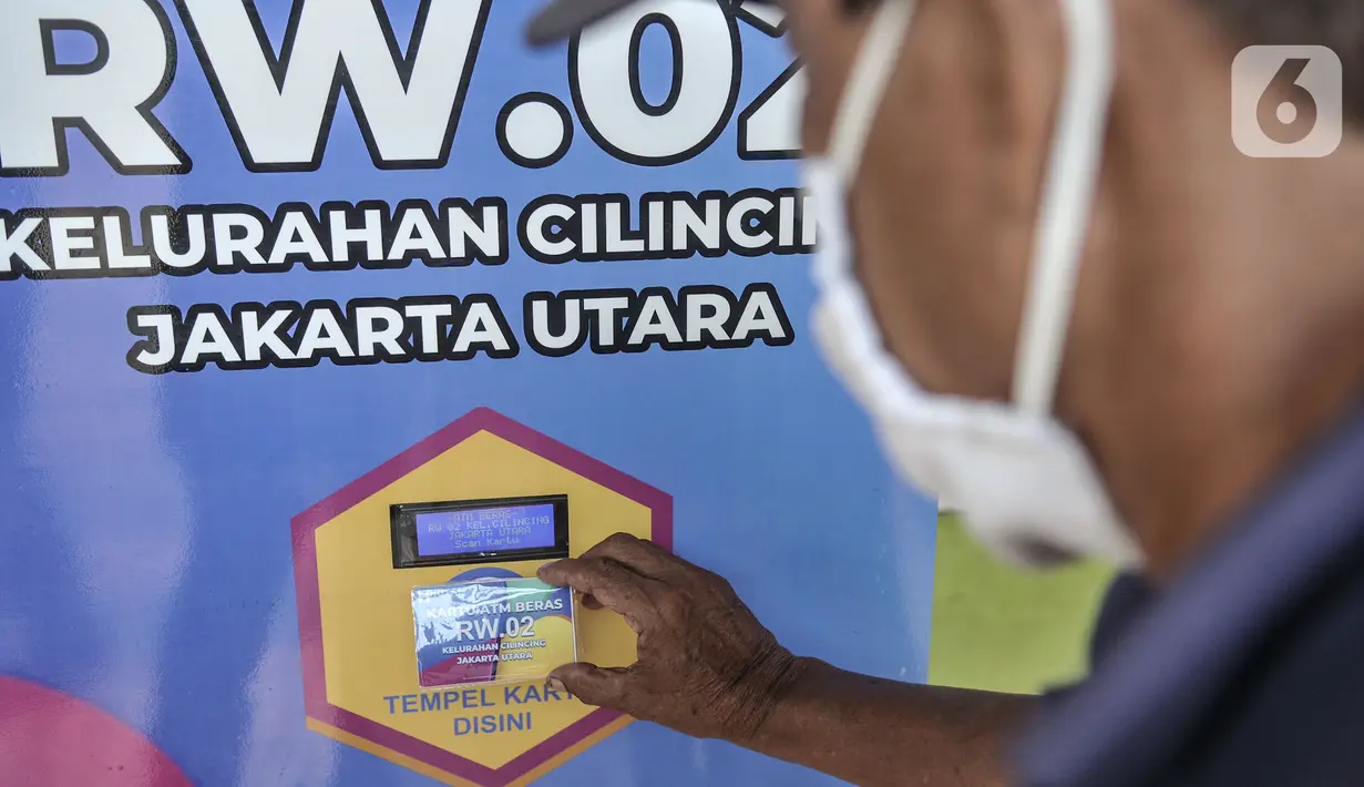 Warga menempelkan kartu pada mesin ATM saat mengambil bantuan beras di Kantor RW 02, Kelurahan Cilincing, Jakarta Utara, Rabu (17/3/2021).  Program ini dibagikan secara berkala selama 2 kali dalam sebulan dengan jatah masing-masing 3 kilogram beras per orang. (merdeka.com/Iqbal S. Nugroho)