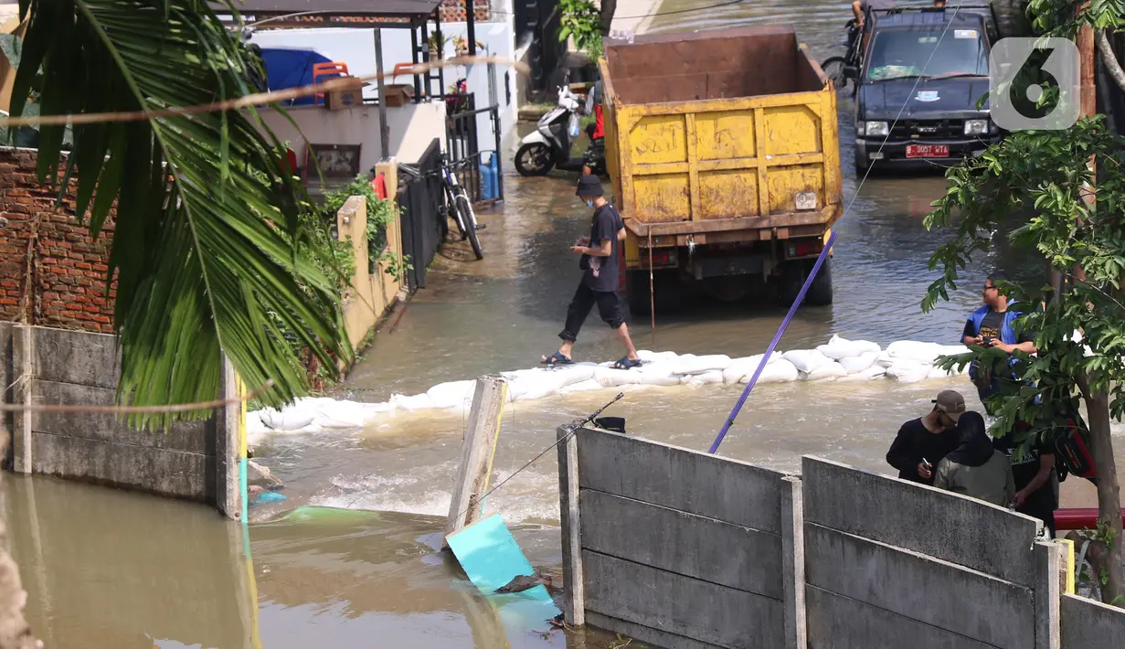 Kondisi banjir di Perumahan Nerada Estate Ciputat akibat jebolnya tanggul karena tertimpa tanah longsor, di Tangerang Selatan, Banten, Sabtu (12/6/2021). Longsor yang menimpa sejumlah rumah membuat tanggul pembatas kali jebol dan air meluap sehingga menyebabkan banjir. (Liputan6.com/Angga Yuniar)