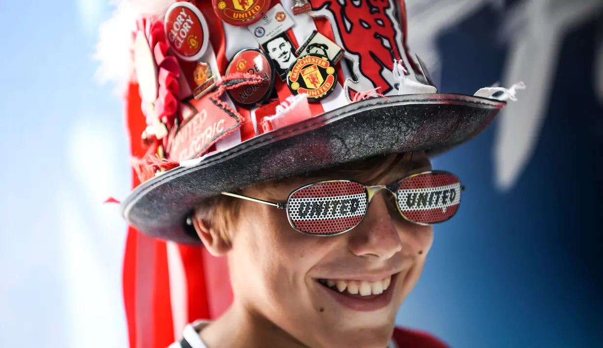 Pendukung Manchester United memakai aksesoris dikepalanya  jelang pertandingan final UEFA Super Cup antara Real Madrid melawan MU di Philip II Arena di zona penggemar di Skopje, Macedonia, (7 /8). (AFP Photo/Armend Nimani)