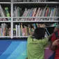 Seorang anak membaca buku di mobil Perpustakaan Keliling di Klungkung, Bali, Sabtu (30/09). Perpustakaan Keliling ini hadir untuk memberikan hiburan bagi korban Gunung Agung khususnya anak-anak.  (Liputan6.com/Gempur M Surya)