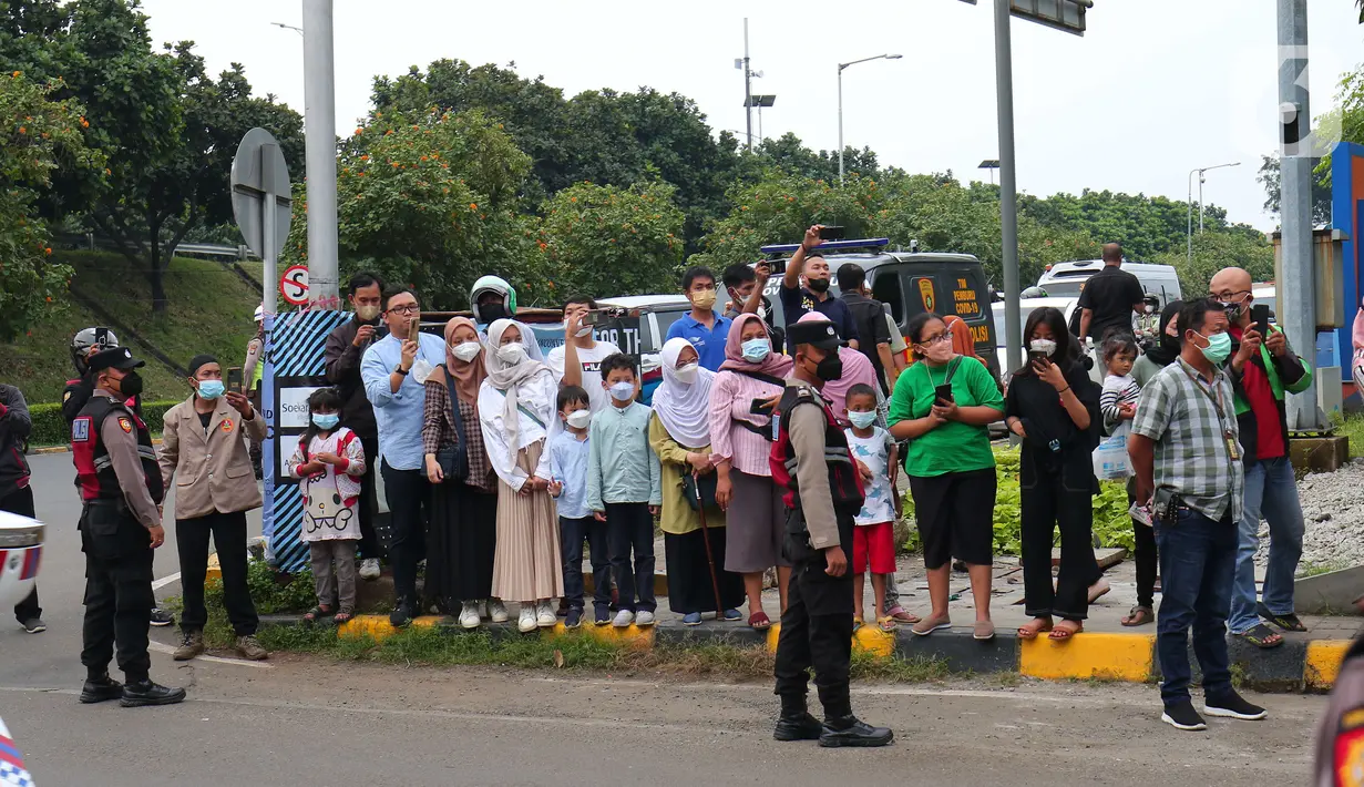 Sejumlah masyarakat mengiringi kepulangan jenazah Emmeril Kahn Mumtadz atau Eril saat iring-iringan ambulan keluar dari Bandara Soekarno-Hatta, Minggu (12/6/2022). Ridwan Kamil langsung membawa jenazah Eril menuju Bandung Jawa Barat untuk di makamkan. (Liputan6.com/Angga Yuniar)