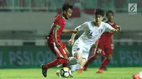 Pemain tengah Timnas Indonesia U-23. M Hargianto (kiri) berebut bola dengan pemain Korea Selatan U-23 pada laga persahabatan di Stadion Pakansari, Kab Bogor, Sabtu (23/6). Babak pertama Indonesia U-23 tertinggal 0-1. (Liputan6.com/Helmi Fithriansyah)
