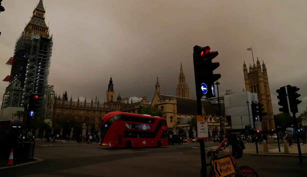 Penampakan langit di atas Big Ben dan Gedung Parlemen yang berwarna kuning kusam menyelimuti kota London, Senin (16/10). Fenomena langit yang menjadi mencekam ini disebabkan oleh badai Ophelia yang membawa debu dari Gurun Sahara. (AP Photo/Frank Augstein)