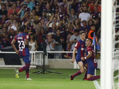 Para pemain Barcelona merayakan gol yang dicetak oleh Ferran Torres ke gawang Real Betis pada laga Liga Spanyol di Estadi Olimpic Lluis Companys, Minggu (17/9/2023). Barca menang dengan skor 5-0. (AP Photo/Joan Monfort)