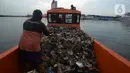 Petugas dari Dinas Lingkungan Hidup DKI Jakarta mengangkut sampah di Pelabuhan Kali Adem, Muara Angke, Jakarta, Rabu (6/1/2021). Dalam sehari, sampah pesisir Teluk Jakarta Utara bisa terangkut sekitar 7 kubik sampah plastik yang terbawa dari sungai maupun arus laut. (merdeka.com/Imam Buhori)